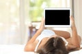 Girl on a bed showing a blank tablet screen Royalty Free Stock Photo