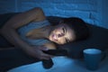 Girl in bed using mobile phone late at night at dark bedroom lying happy and relaxed Royalty Free Stock Photo