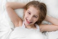 Girl in bed wide awake, hands under head Royalty Free Stock Photo