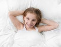 Girl in bed wide awake, hands under head Royalty Free Stock Photo