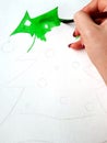 The girl began to paint a new-year decorated Christmas tree with watercolor.