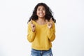 Girl begging god fulfill her dream. Pretty excited young african american woman in yellow sweater, raise head up cross Royalty Free Stock Photo