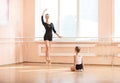 Girl beginner watching classmate standing en pointe