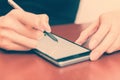 The girl behind the Desk with a smartphone and stylus. Royalty Free Stock Photo