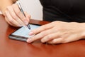 The girl behind the Desk with a smartphone and stylus. Royalty Free Stock Photo