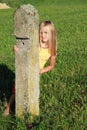 Girl behind the stone bollard Royalty Free Stock Photo