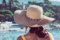 Girl from behind with straw hat on her head. Woman explorer traveler. Blurred background