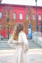 A girl in a beige raincoat against the background of Taras Shevchenko University. Royalty Free Stock Photo