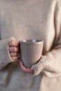 Girl in beige sweater holding cup of coffee or tea Royalty Free Stock Photo