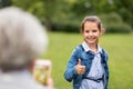 Girl being photographed and showing thumbs up Royalty Free Stock Photo