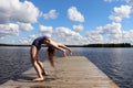 Girl bending over backwards into a backbend at a lake in Finland Royalty Free Stock Photo