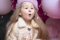 Girl in beret playing with pink, purple balloons, soap bubbles, marshmallow Royalty Free Stock Photo