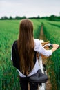 A girl on a bicycle with a basket in the middle of a wheat field Royalty Free Stock Photo