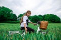 A girl on a bicycle with a basket in the middle of a wheat field Royalty Free Stock Photo