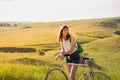 Girl with bicycle in beautiful rural landscape at sunset. Young Royalty Free Stock Photo