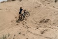Girl with a bicycle climb the sand dunes