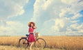 Girl with bicycle on field. Royalty Free Stock Photo