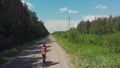 Girl on a Bicycle rides on a dirt road in the village. Cycling on the nature, forest.