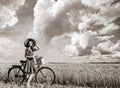 Girl with bicycle on wheat field Royalty Free Stock Photo