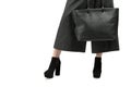 Girl with a big black bag and high-heeled shoes Royalty Free Stock Photo