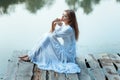 Girl with big eyes sitting on the wharf bored. Royalty Free Stock Photo