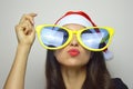 Girl with big funny sunglasses and Santa Claus hat celebrates Christmas Royalty Free Stock Photo