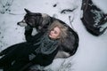 Girl with big malamute dog on winter background.