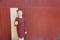 girl with big ruler standing on red wooden background. Farewell Bell. day of knowledge. beginning of the school year Royalty Free Stock Photo