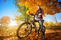 Girl with bike on a autumn leafs background