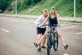 Girl on bike, guy runs. boy teaches girl to ride a bike. Morning Meadow. Royalty Free Stock Photo