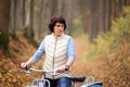 The girl on a bike from the rental in the forest. Girl in a yellow autumn forest. Royalty Free Stock Photo