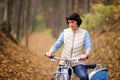 The girl on a bike from the rental in the forest. Girl in a yellow autumn forest. Royalty Free Stock Photo