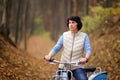 The girl on a bike from the rental in the forest. Girl in a yellow autumn forest. Royalty Free Stock Photo