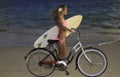 Girl with bike and surfboard Royalty Free Stock Photo