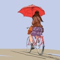 Girl on bike with umbrella autumn rain