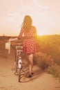 Girl with bike walking in countryside