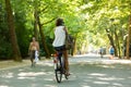 A girl biking and calling in a park in Amsterdam.