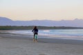 Girl biking on the empty beach. Itaguare beach, Bertioga, Brazil.