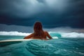 A girl in a bikini is laying on her surfboard Royalty Free Stock Photo