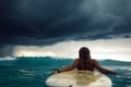 A girl in a bikini is laying on her surfboard Royalty Free Stock Photo