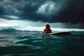 A girl in a bikini is laying on her surfboard Royalty Free Stock Photo