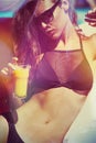 Girl in bikini and sunglasses by the pool with juice Royalty Free Stock Photo