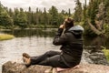 Girl with binocular sitting near Lake of two rivers in Algonquin National Park Canada Ontario natural pinetree landscape Royalty Free Stock Photo