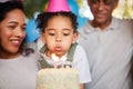 Girl, birthday party and blow candles with cake, celebration and support with applause, hat and happy in family home Royalty Free Stock Photo