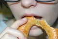 The girl bites off a sweet bagel with poppy seeds Royalty Free Stock Photo