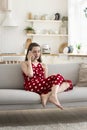 Girl blab on smartphone seated on sofa at home Royalty Free Stock Photo