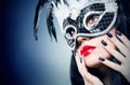 Girl in black carnival mask with manicure