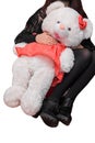 A girl in black clothes in a sitting position holds a large soft white toy of a fluffy bear girl on an isolated background Royalty Free Stock Photo