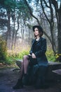 Girl in a black coat sitting on a bench Royalty Free Stock Photo