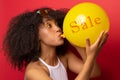 Girl inflates the ball with the inscription sales